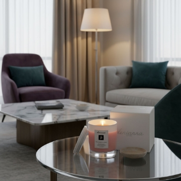 Luxury Mediterranean Home Fragrance by elenianna elenianna Milos Whispers of Love artisan candle creating a warm, sophisticated ambiance on a glass table in a modern living room.