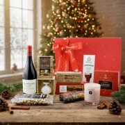 Festive display of the gourmet Greek food gift, with Xinomavro wine and artisanal treats on a rustic Christmas table