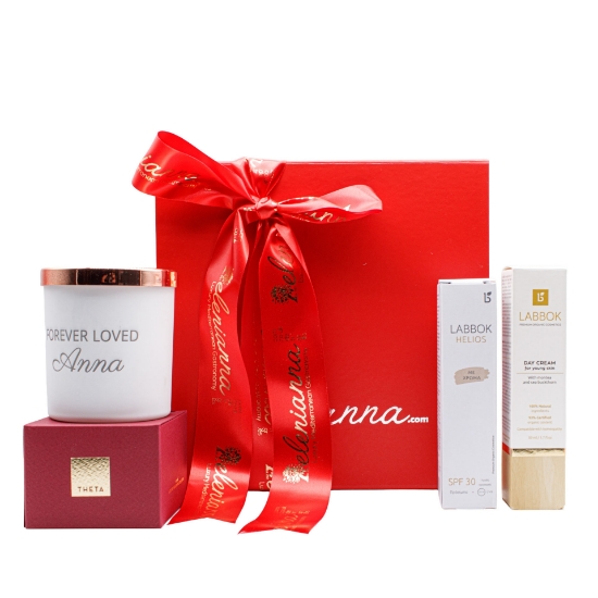 A luxury red gift box featuring a personalized "Forever Loved" candle, Labbok organic skincare, and Theta rose petal honey for Valentine's Day gifting.